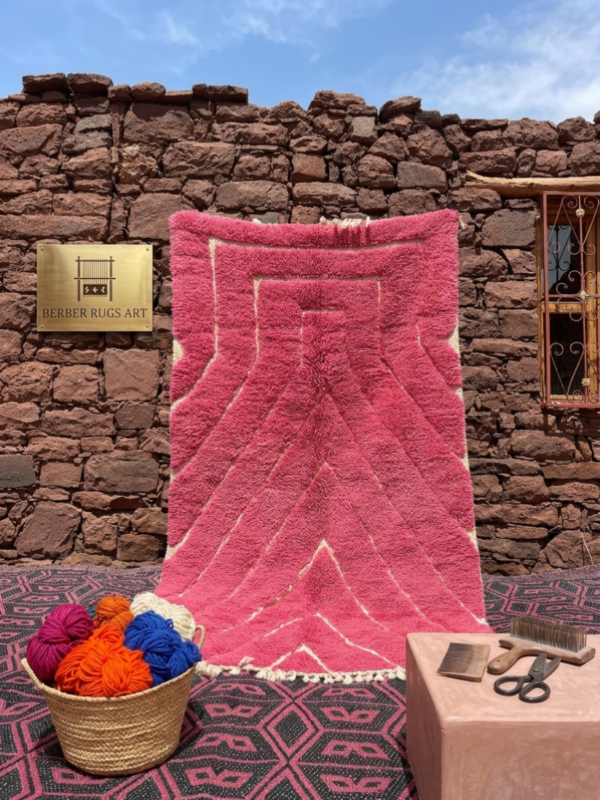 Handwoven Mrirt rug with pink geometric pattern in Moroccan outdoor setting