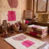 Handwoven Azilal rug with pink geometric pattern on ivory wool in Moroccan interior
